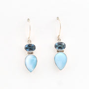 Pair of earrings with blue teardrop-shaped stones on a white background