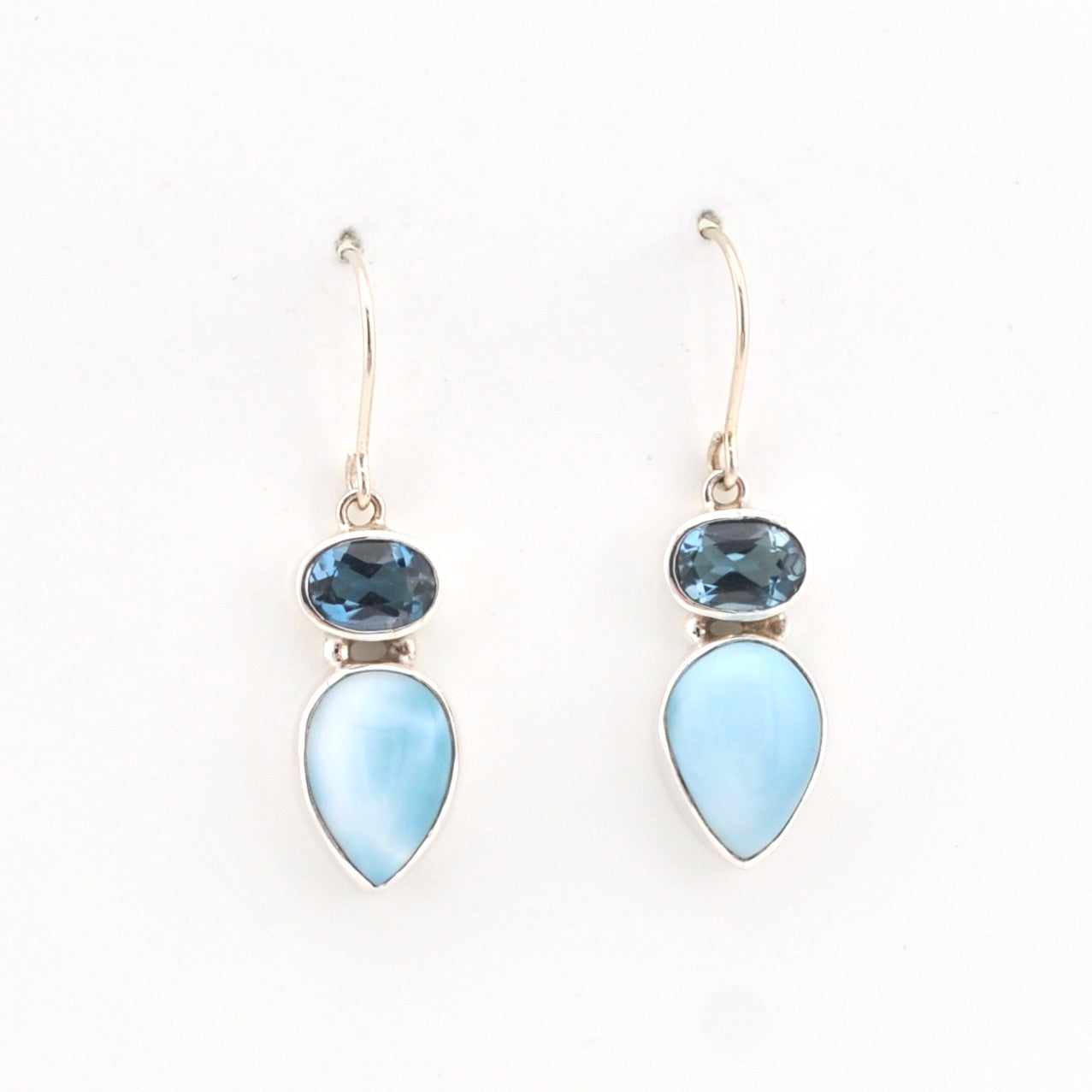 Pair of earrings with blue teardrop-shaped stones on a white background