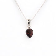 Necklace with a teardrop-shaped garnet pendant on a white background