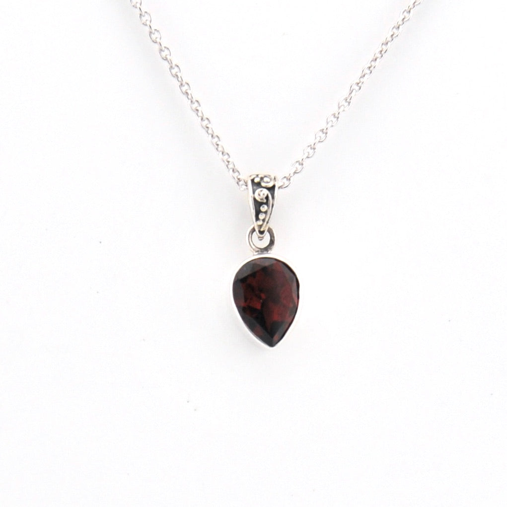 Necklace with a teardrop-shaped garnet pendant on a white background