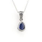 Silver pendant with a blue gemstone on a white background