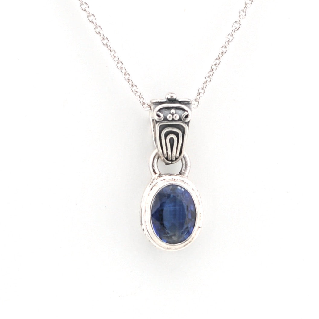 Silver pendant with a blue gemstone on a white background