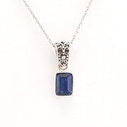 Silver necklace with a blue gemstone pendant on a white background