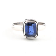 Silver ring with a blue gemstone on a white background