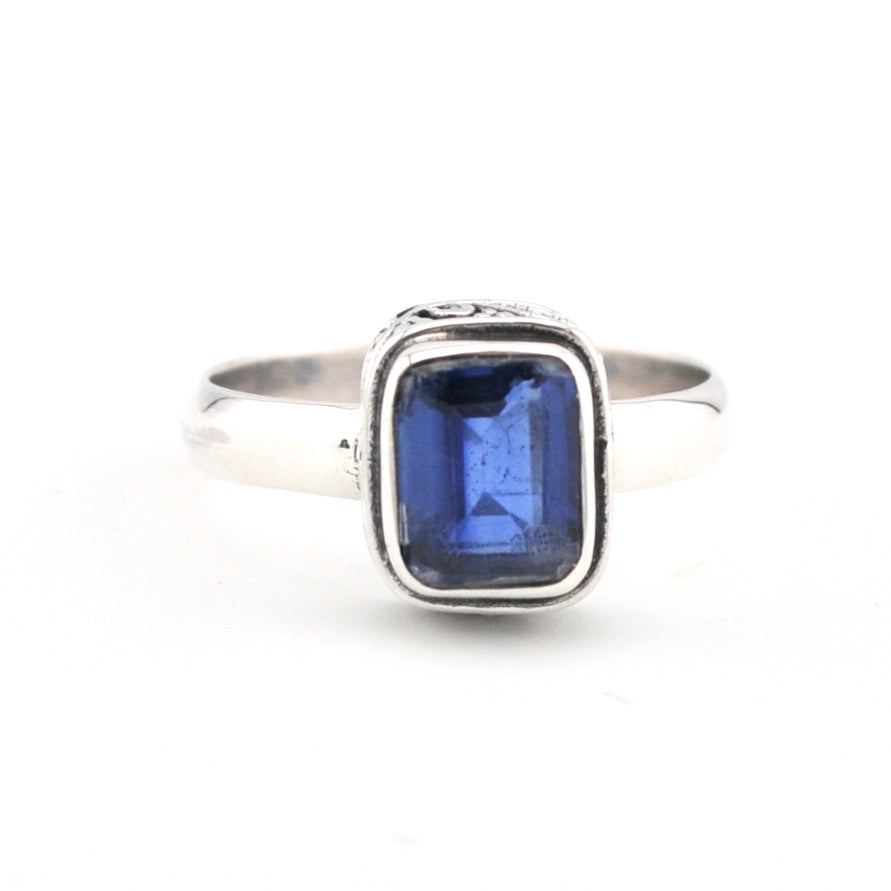 Silver ring with a blue gemstone on a white background
