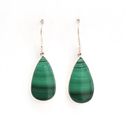 Teardrop-shaped green earrings on a white background