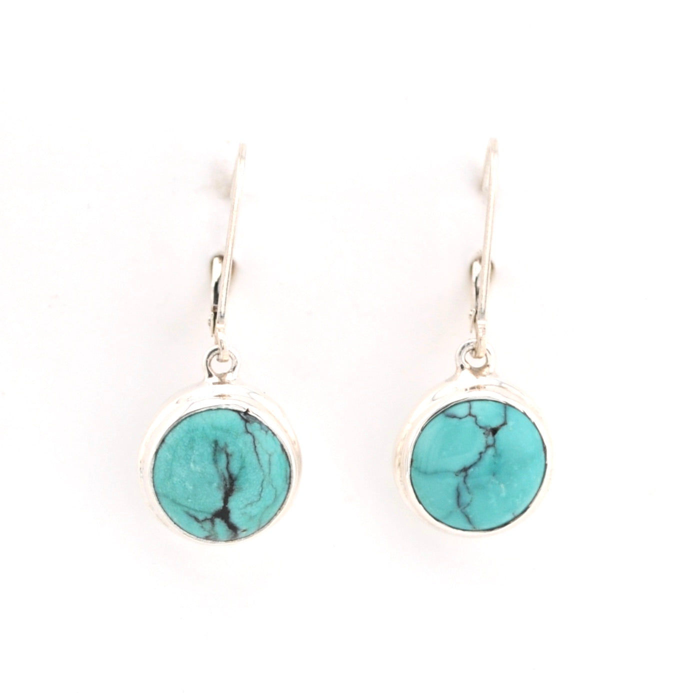 Turquoise round earrings on silver hooks against a white background