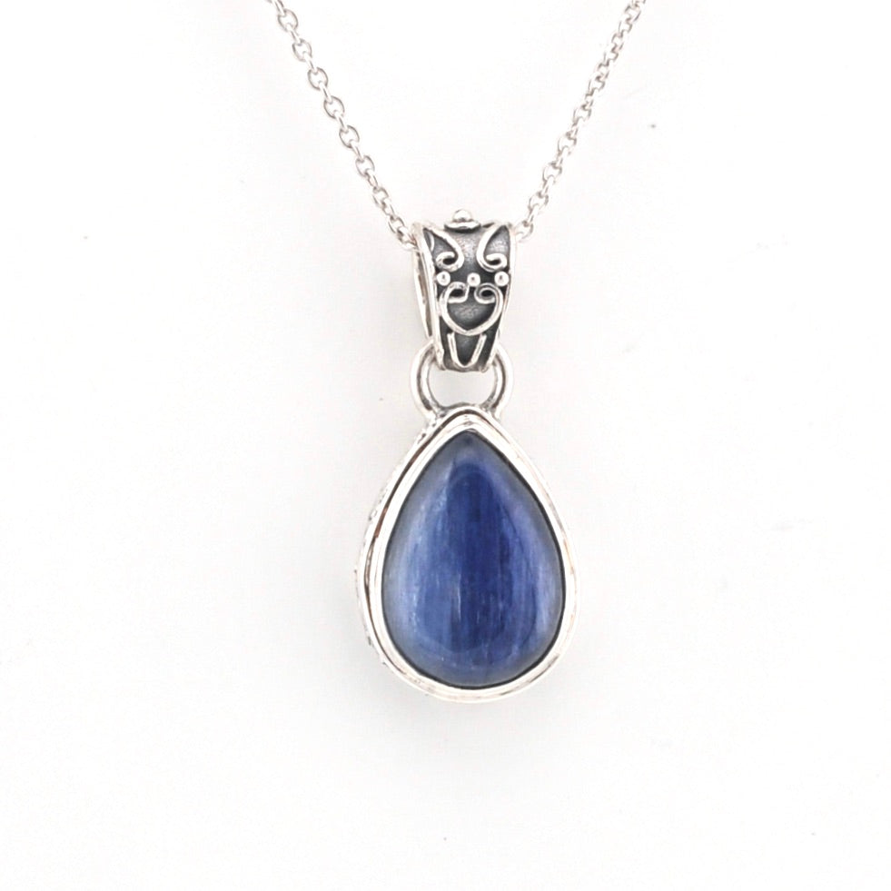 Teardrop-shaped blue stone pendant on a silver chain against a white background