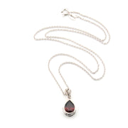 Silver necklace with a teardrop-shaped pendant on a white background