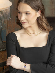 Woman wearing gold jewelry with a blurred background