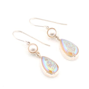 Pair of earrings with teardrop-shaped gemstones and pearls on a white background