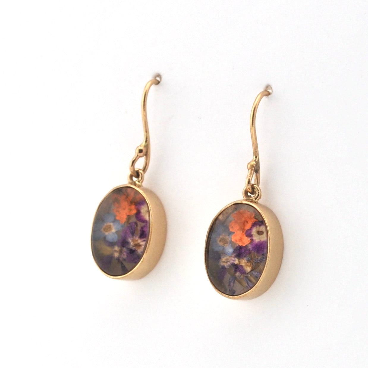 Gold-framed earrings with floral design on a white background