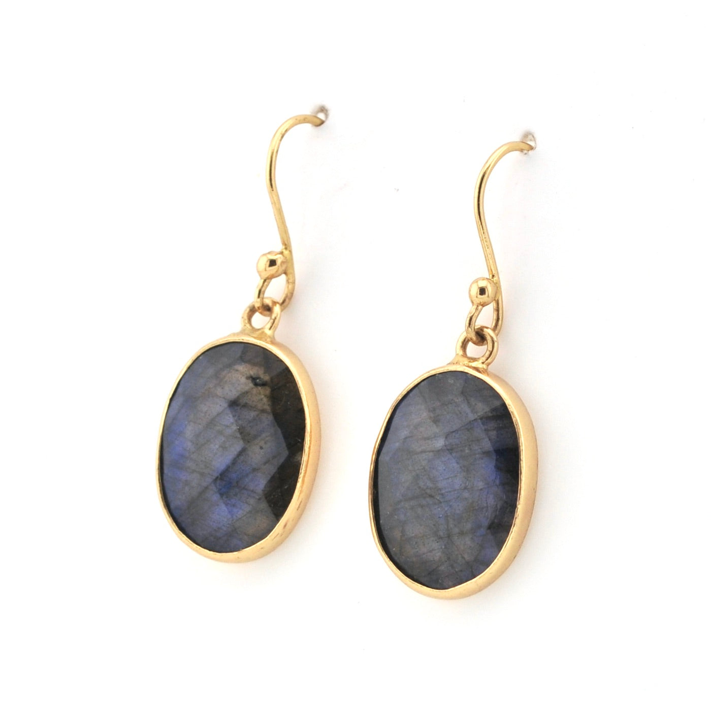 Gold earrings with blue gemstones on a white background