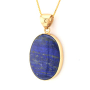 Gold pendant with a blue stone on a white background