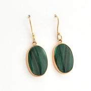Gold-framed green stone earrings on a white background
