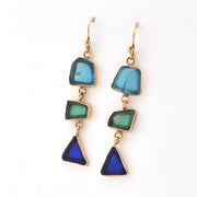 Pair of earrings with blue and green triangular stones on a white background