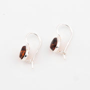 Silver earrings with amber stones on a white background