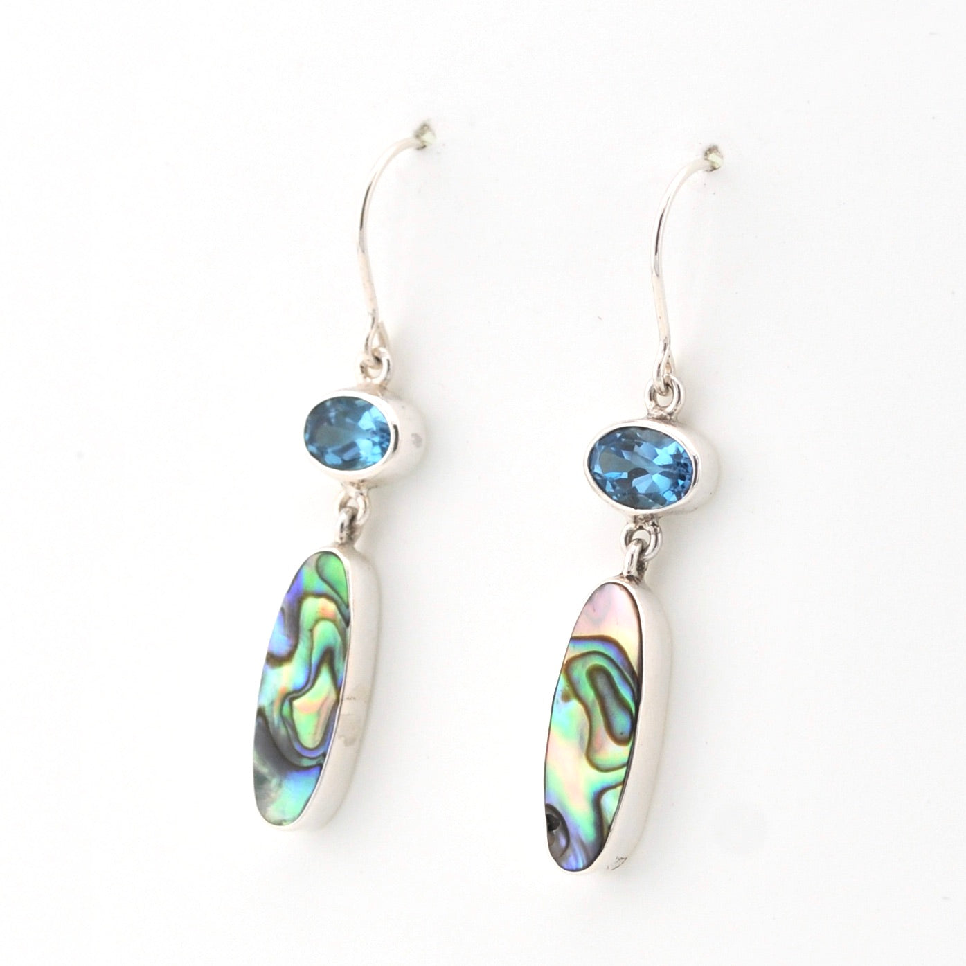 Pair of earrings with colorful shell-like stones and blue gemstones on a white background