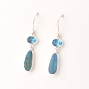 Pair of silver earrings with blue gemstones on a white background