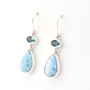 Pair of earrings with blue teardrop-shaped stones on a white background