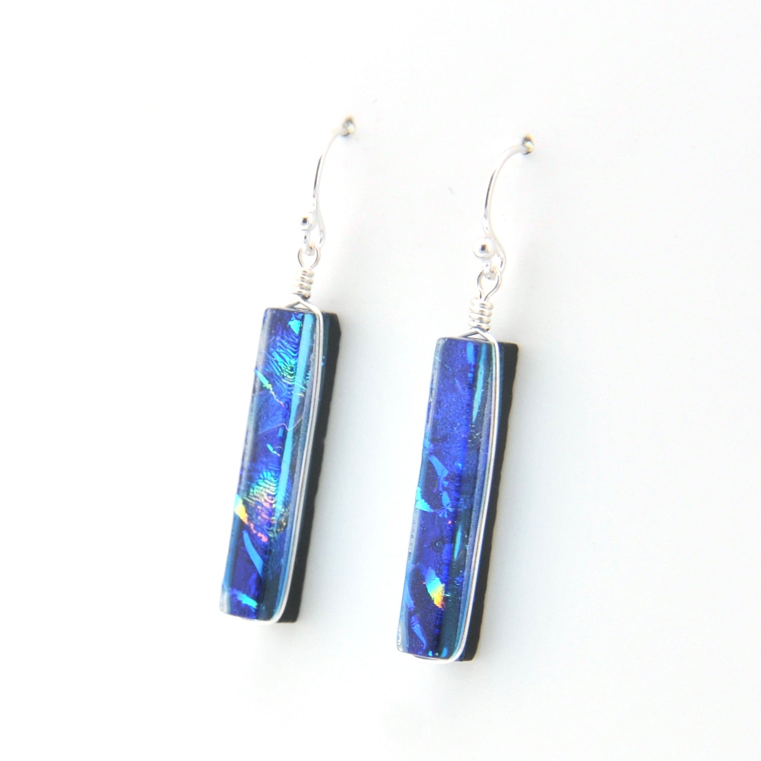 Pair of blue iridescent earrings on a white background