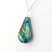 Teardrop-shaped pendant with multicolored iridescent finish on a white background