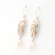 Pair of earrings with shell and pearl elements on a white background