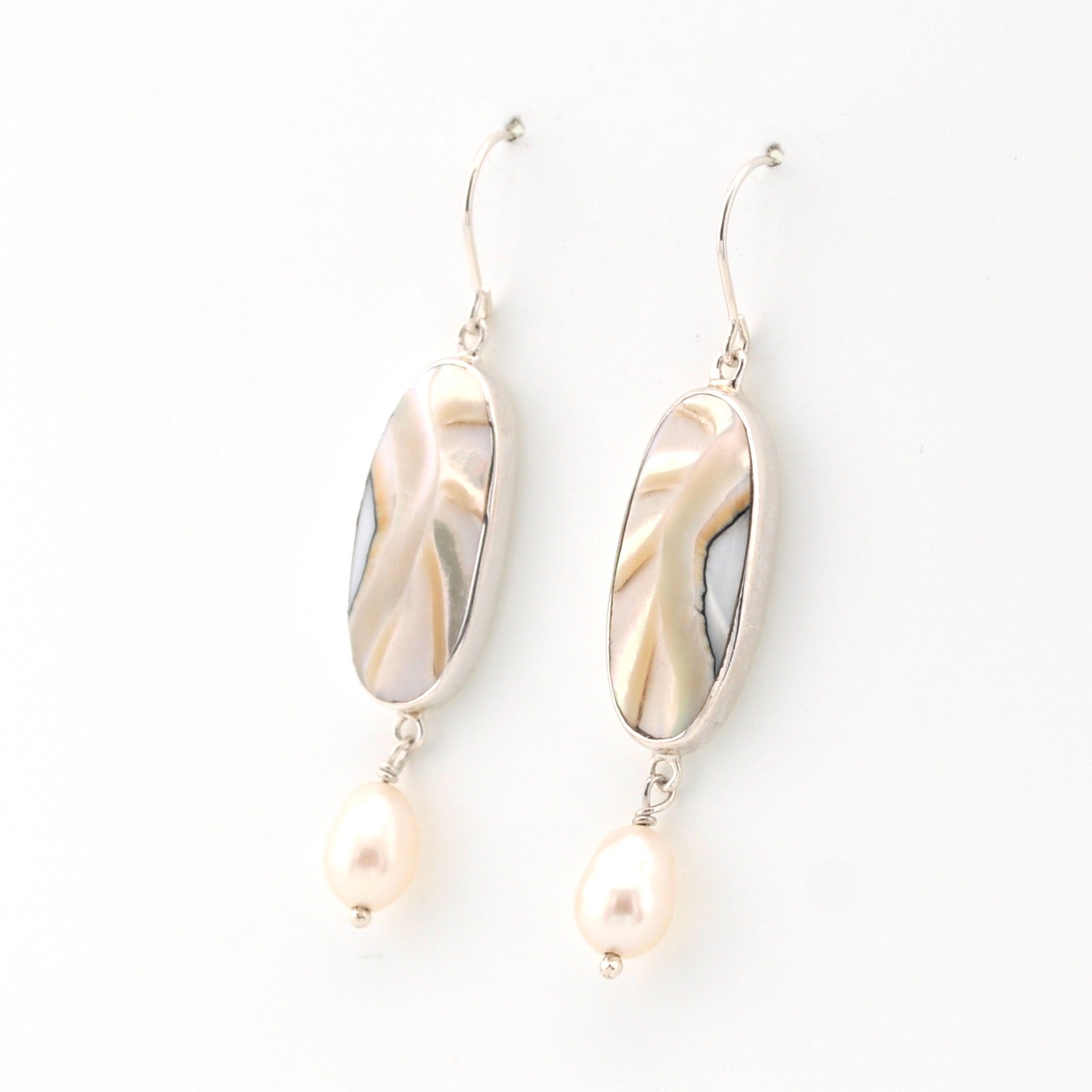 Pair of earrings with shell and pearl elements on a white background