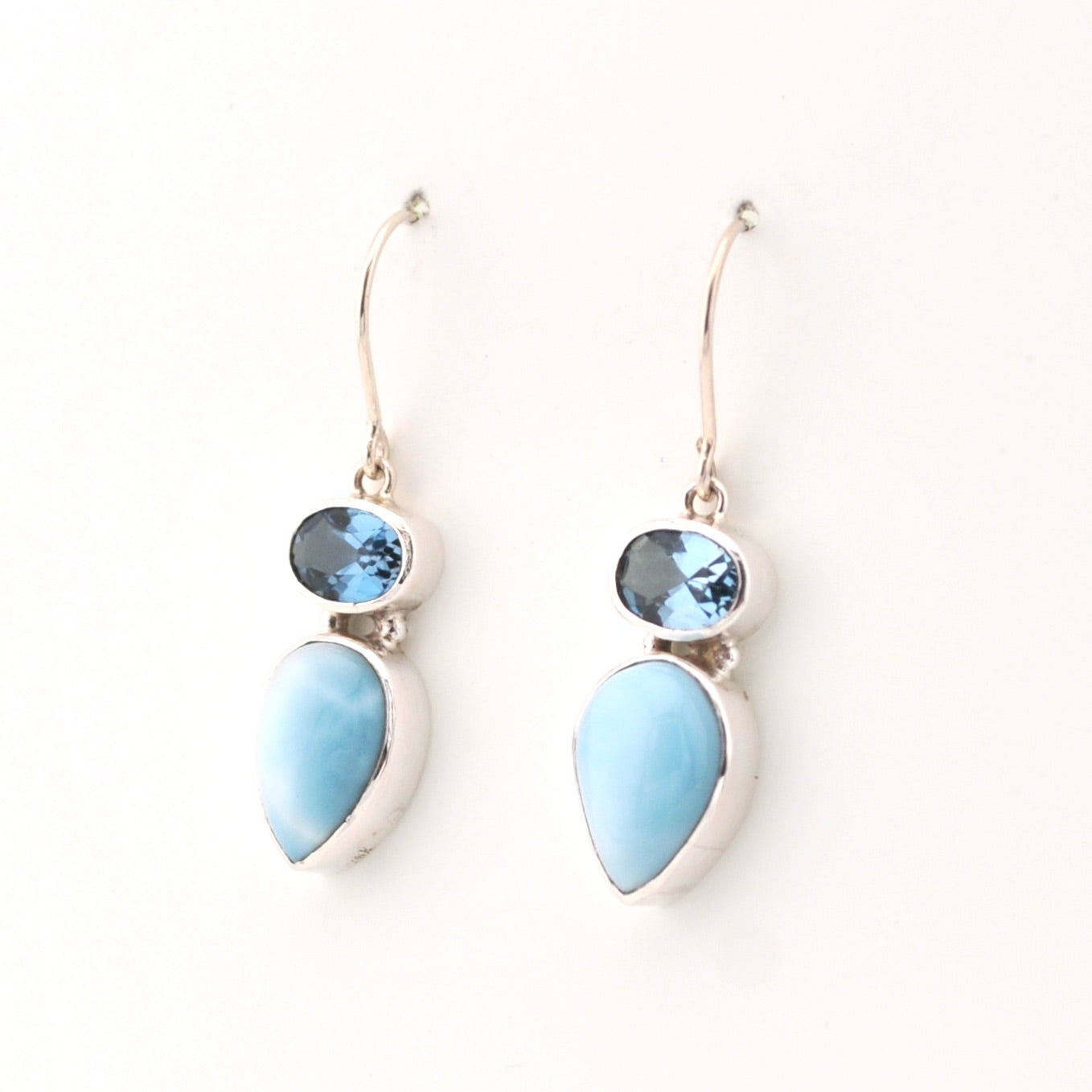 Pair of earrings with blue teardrop-shaped stones on a white background