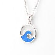 Silver necklace with a blue wave pendant on a white background