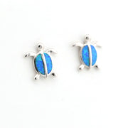 Turtle-shaped earrings with blue opal inlay on a white background