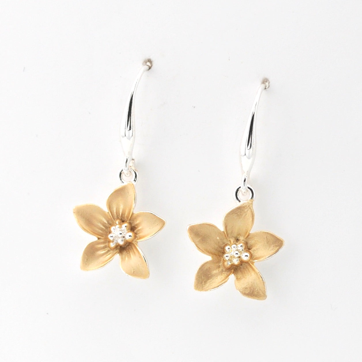 Gold flower-shaped earrings on a white background