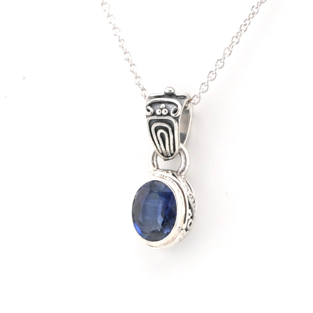 Silver pendant with a blue gemstone on a white background