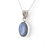 Silver pendant with a blue stone on a white background