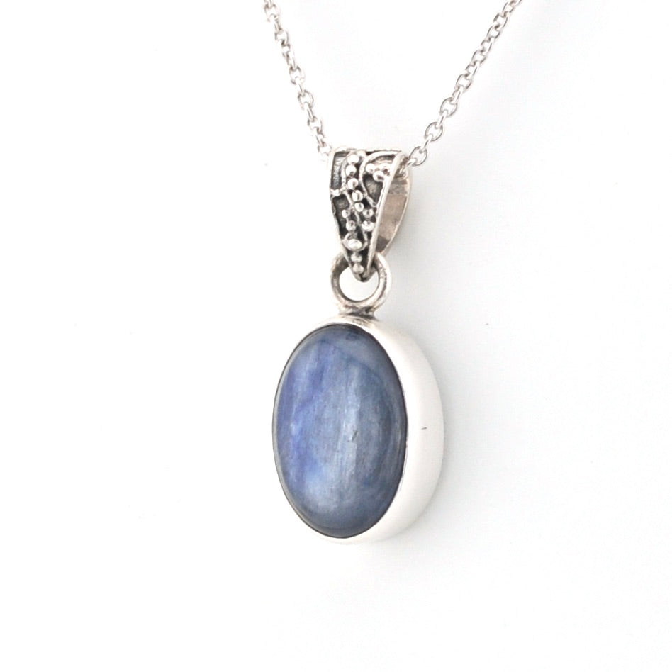 Silver pendant with a blue stone on a white background