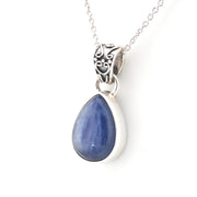 Teardrop-shaped blue kyanite pendant on a silver chain against a white background