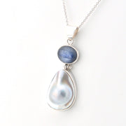 Necklace with a teardrop-shaped pearl and blue gemstone on a white background