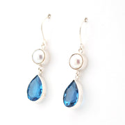 Pair of earrings with blue teardrop-shaped stones and pearl tops on a white background