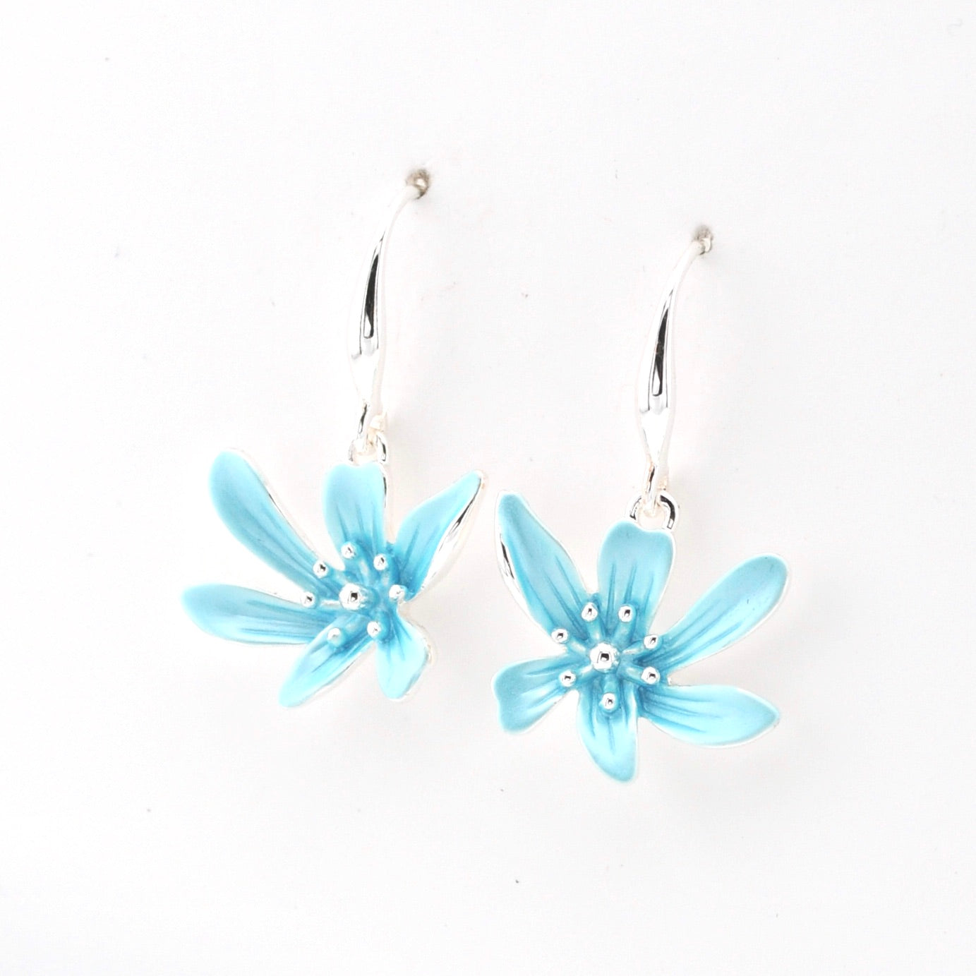 Pair of light blue flower-shaped earrings on a white background