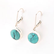 Turquoise stone earrings with silver hooks on a white background