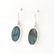 Oval-shaped Labradorite earrings on silver hooks against a white background