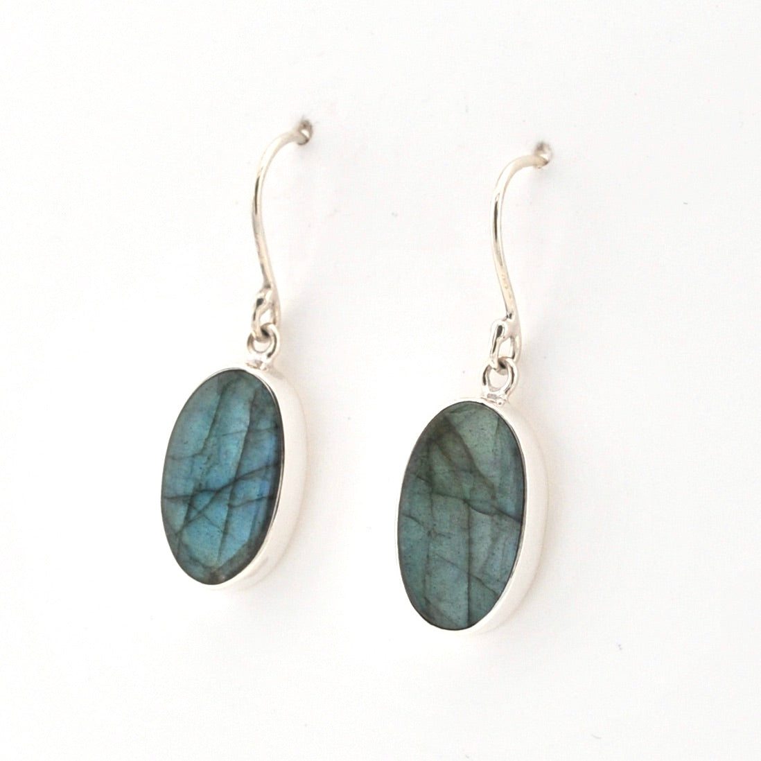 Oval-shaped Labradorite earrings on silver hooks against a white background