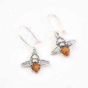Silver bee earrings with amber stones on a white background
