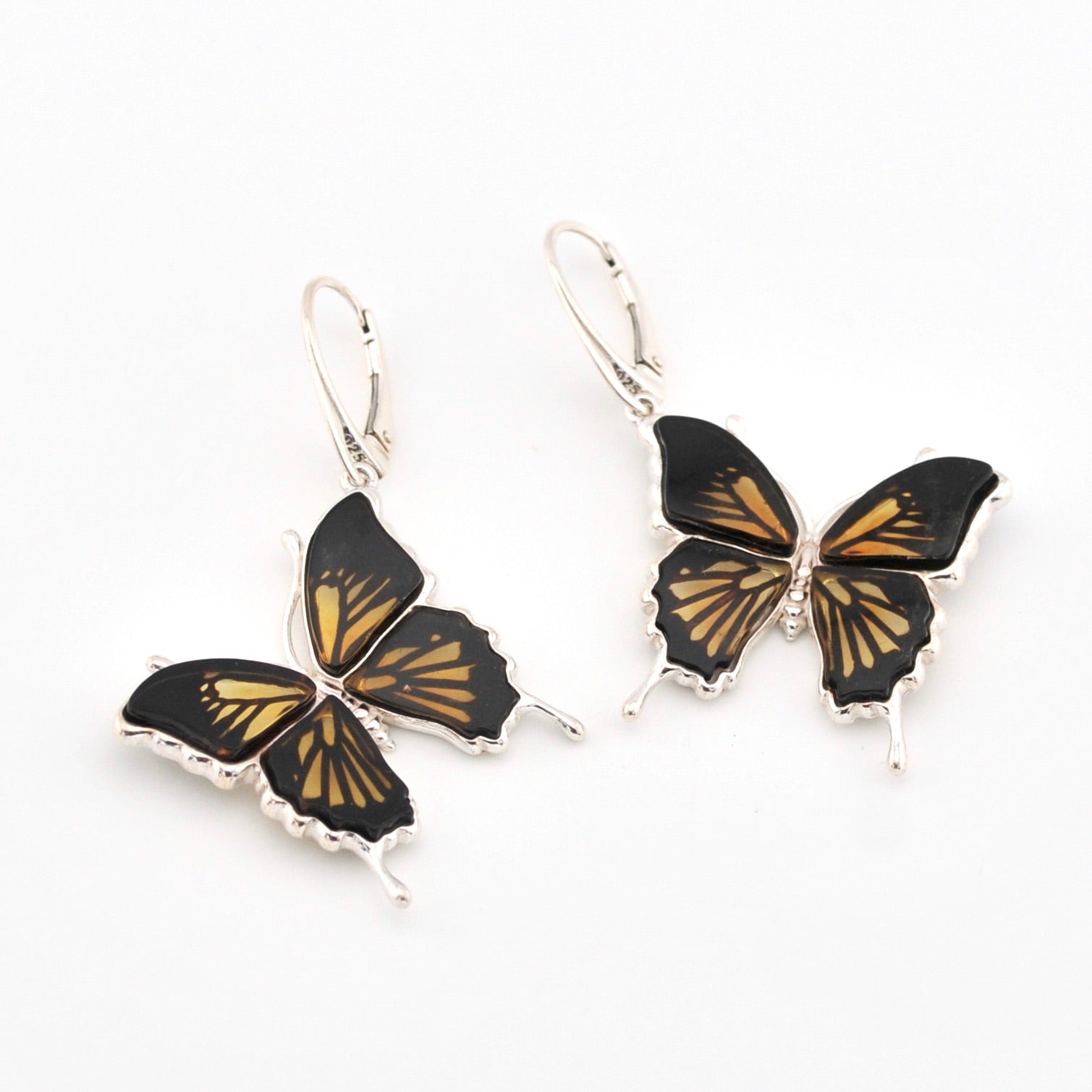 Butterfly-shaped earrings with black and gold design on a white background