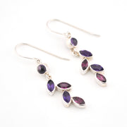 Silver earrings with purple gemstones on a white background