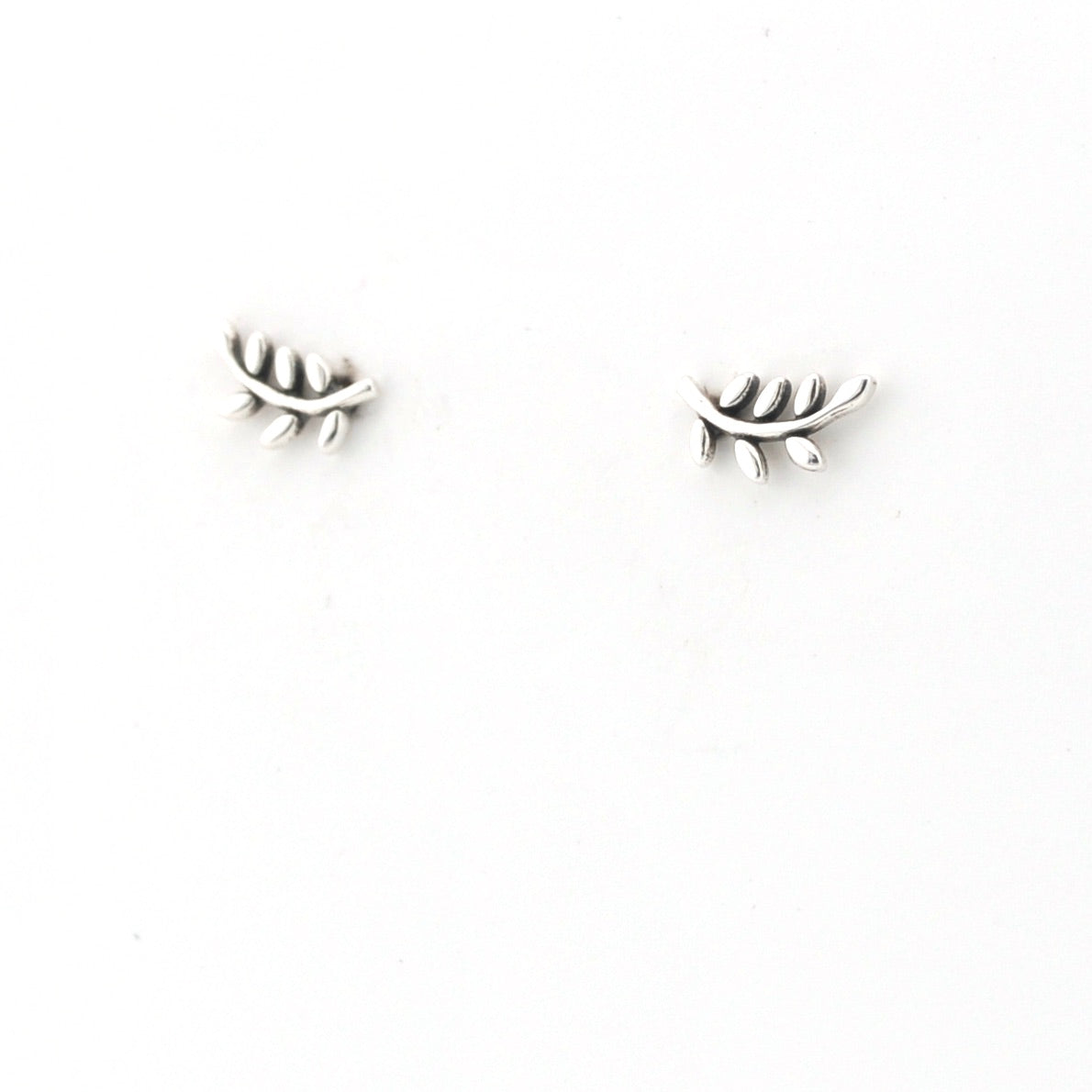 Pair of silver branch-shaped earrings on a white background