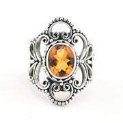Silver ring with an orange gemstone on a white background
