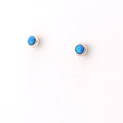 Pair of silver earrings with blue gemstones on a white background