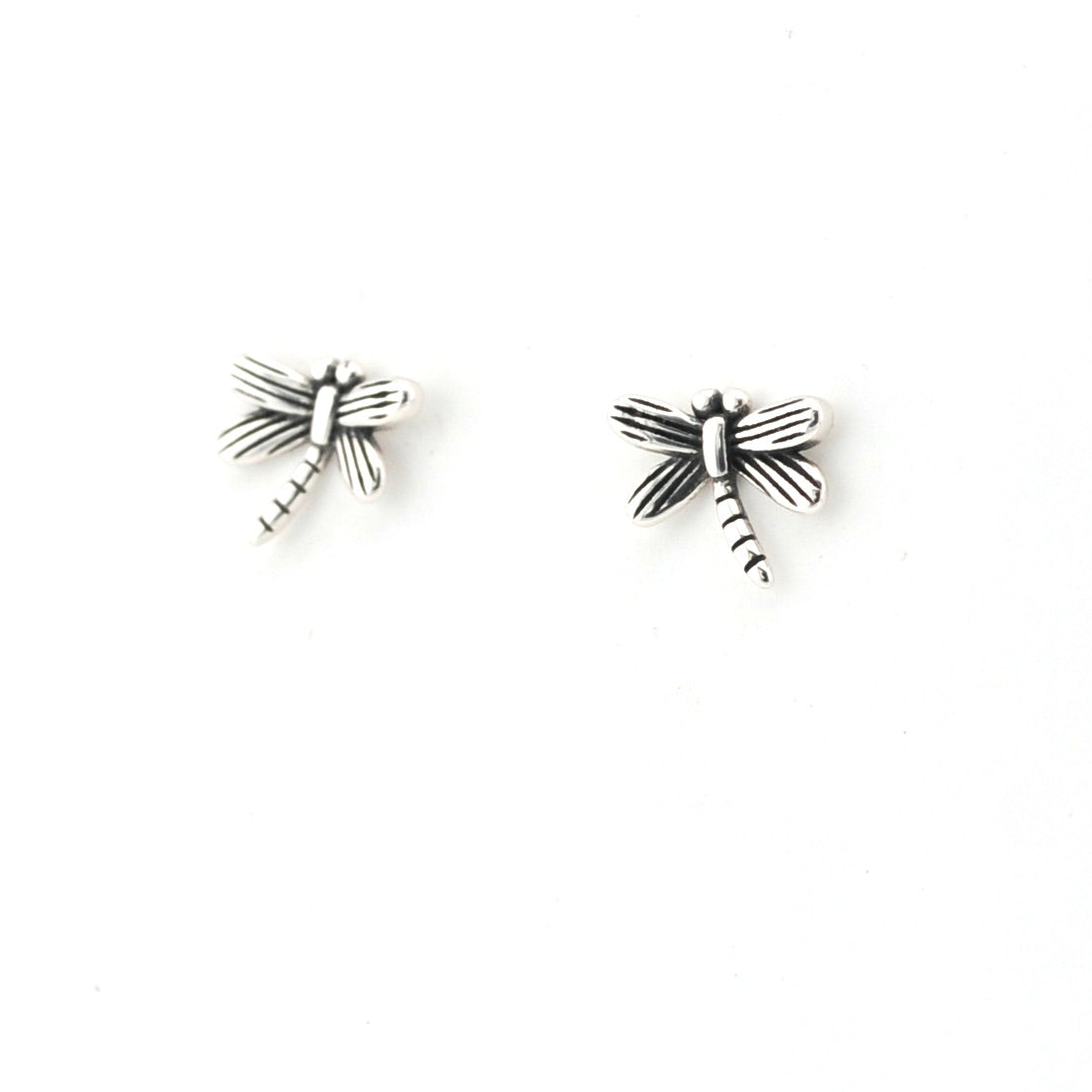 Pair of silver dragonfly-shaped earrings on a white background