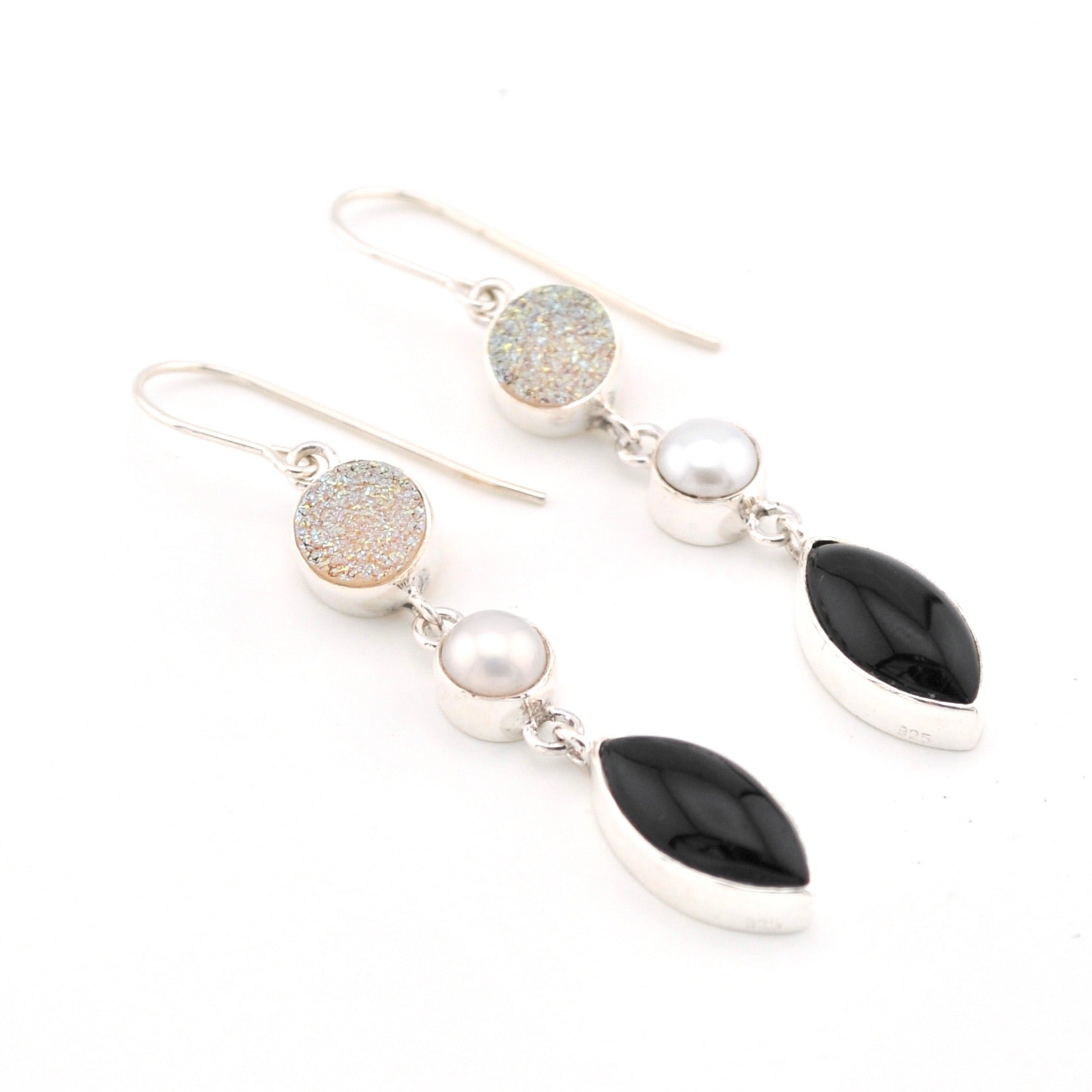 Earrings with black, white, and gold stones on a white background
